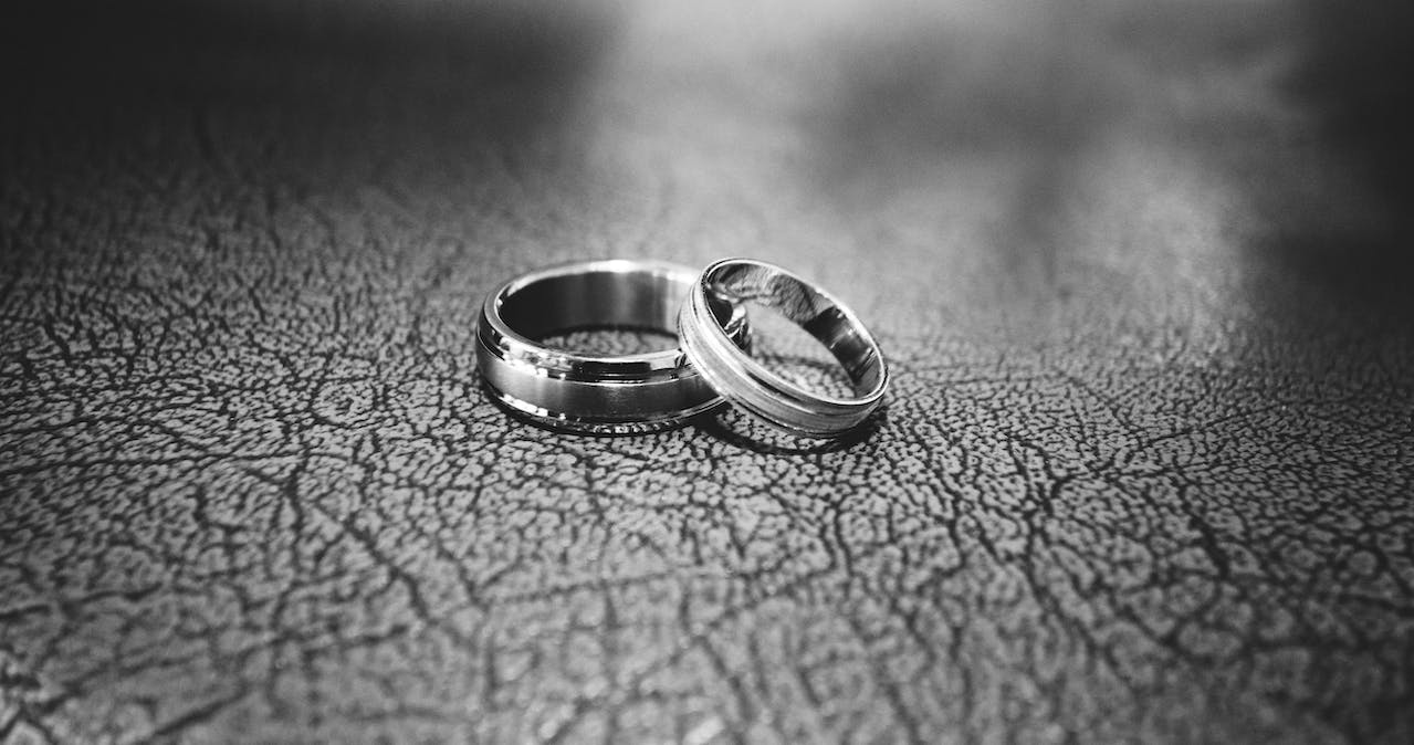 two wedding rings resting on a flat, leather surface