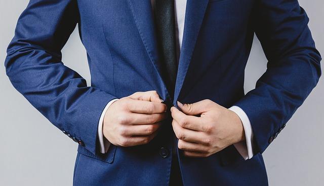 a man buttoning his suit jacket