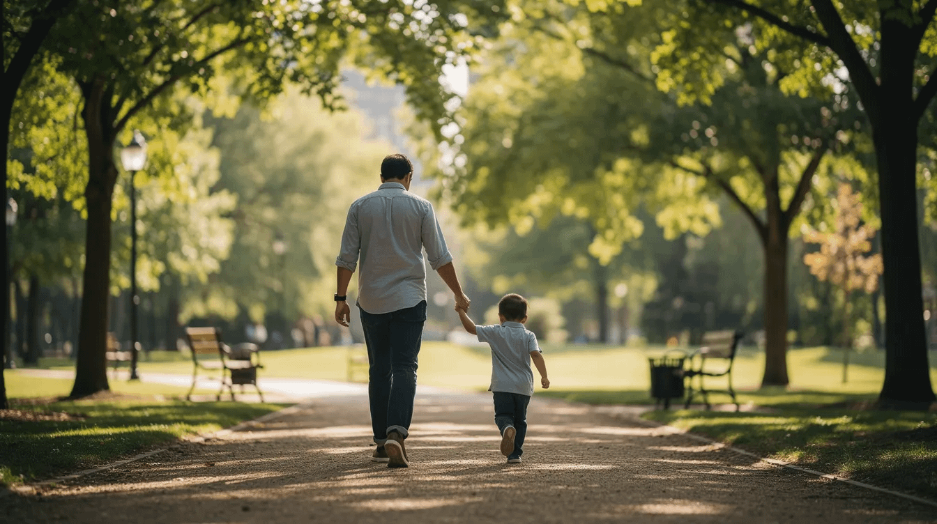 A parent is gently holding the hand of a young child while strolling through a serene park filled with trees, symbolizing the importance of family and nurturing relationships in family law matters such as child custody and divorce mediation. The scene captures a moment of connection and support, reflecting the best interests of children amidst family disputes.